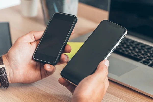 Hombre usando el teléfono inteligente móvil. Hombre de negocios manos usando el teléfono celular en el escritorio de la oficina . — Foto de Stock