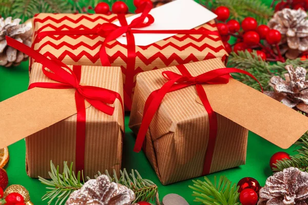 Виготовлення різдвяних подарунків з червоними стрічками на прикрашеному різдвяному фоні — стокове фото