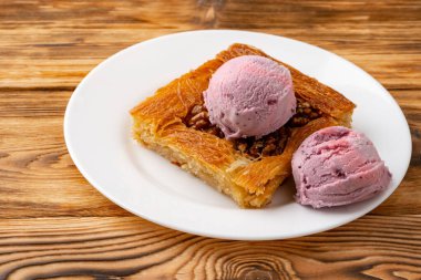 Türk tatlısı, ahşap arka planda dondurmayla servis edilir.