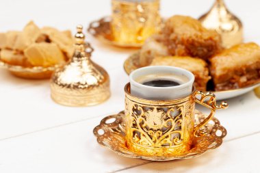 Bir fincan sıcak çay ve bir tabak Türk tatlısı.