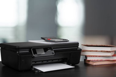 Masasında bulanık arkaplana karşı kitaplarla sıkıştırılmış ev yazıcısı