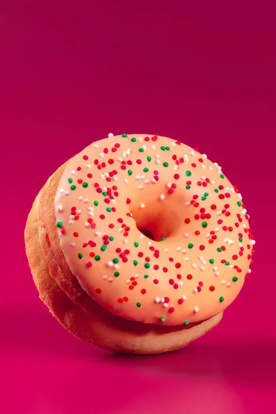 Lecker glasierter runder Donut auf leuchtend rosa Hintergrund — Stockfoto