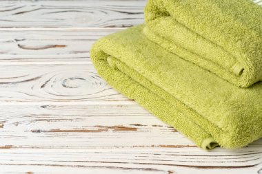 Tahta bir masaya yeni havlular yığdım.