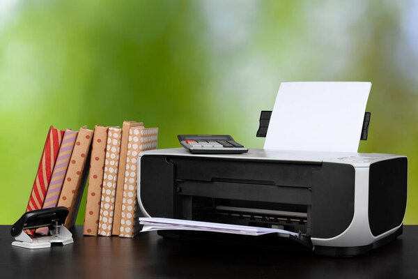 Компактный домашний принтер на столе с книгами на размытом фоне