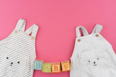 Pembe arka plan görünümlü bebek kıyafetleri