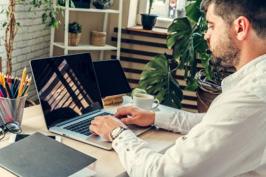 Ofis çalışanı işini yapıyor. Çalışma masasında bilgisayarla oturuyor.