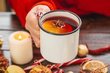 Elinde sıcak şarapla elinde bardak tutan bir kadın.