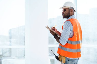 İnşaat alanındaki ustabaşı not defterini kontrol ediyor.