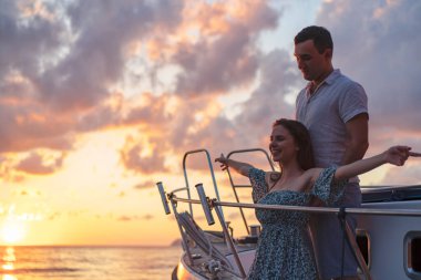 Sevgili çift denizde bir yatta vakit geçiriyor.