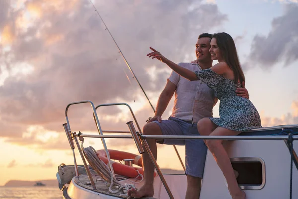 Güzel bir çift yattan gün batımını seyrediyor.