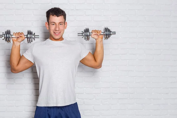 Retrato de un hombre musculoso levantando pesas —  Fotos de Stock