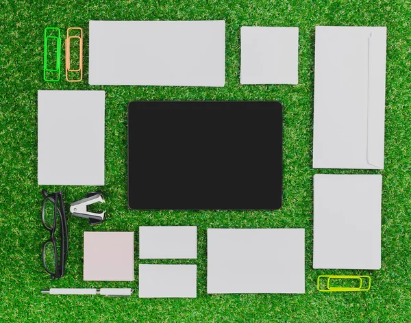 blank notebook, phone on  green grass