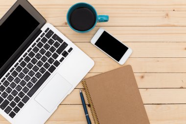 Ofis işyeri açık dizüstü bilgisayar, tablet pc, telefon ve ahşap masa kahve