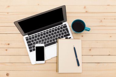 Ofis işyeri açık dizüstü bilgisayar, tablet pc, telefon ve ahşap masa kahve