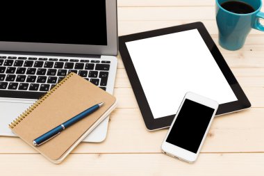 Ofis işyeri açık dizüstü bilgisayar, tablet pc, telefon ve ahşap masa kahve