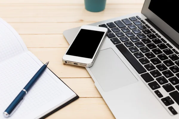 Escritório local de trabalho com laptop aberto, tablet pc, telefone e xícara de café em mesa de madeira — Fotografia de Stock