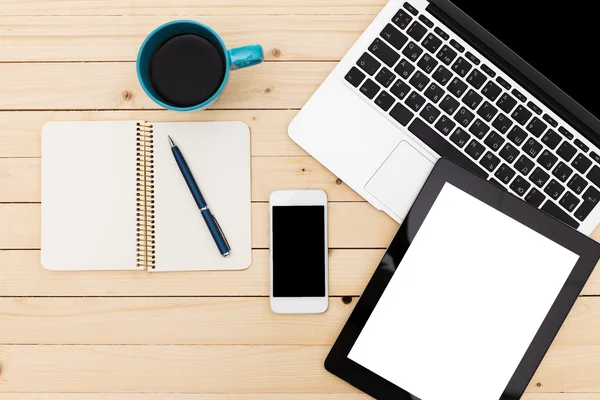 Escritório local de trabalho com laptop aberto, tablet pc, telefone e xícara de café em mesa de madeira — Fotografia de Stock