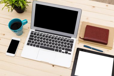 Ofis işyeri açık dizüstü bilgisayar, tablet pc, telefon ve ahşap masa kahve