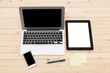 Ofis işyeri açık dizüstü bilgisayar, tablet pc, telefon ve ahşap masa kahve