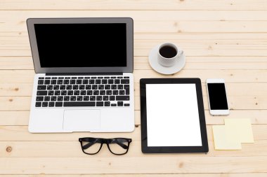 Ofis işyeri açık dizüstü bilgisayar, tablet pc, telefon ve ahşap masa kahve