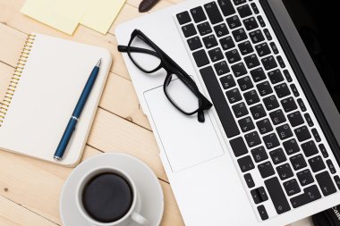 Ofis işyeri açık dizüstü bilgisayar, tablet pc, telefon ve ahşap masa kahve