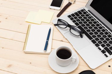 Ofis işyeri açık dizüstü bilgisayar, tablet pc, telefon ve ahşap masa kahve