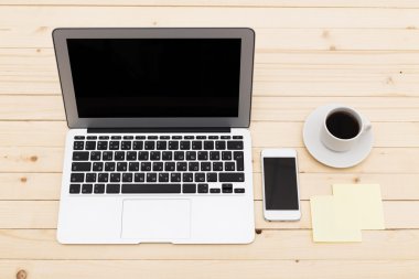 Ofis işyeri açık dizüstü bilgisayar, tablet pc, telefon ve ahşap masa kahve