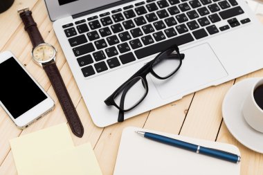 Ofis işyeri açık dizüstü bilgisayar, tablet pc, telefon ve ahşap masa kahve