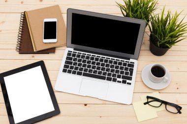 Ofis işyeri açık dizüstü bilgisayar, tablet pc, telefon ve ahşap masa kahve