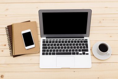 Ofis işyeri açık dizüstü bilgisayar, tablet pc, telefon ve ahşap masa kahve