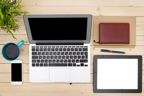 Escritório local de trabalho com laptop aberto, tablet pc, telefone e xícara de café em mesa de madeira — Fotografia de Stock