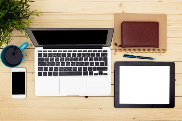 Ofis işyeri açık dizüstü bilgisayar, tablet pc, telefon ve ahşap masa kahve