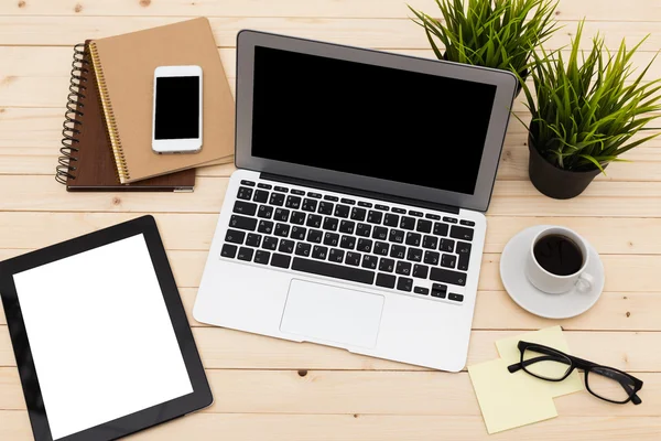 Escritório local de trabalho com laptop aberto, tablet pc, telefone e xícara de café em mesa de madeira — Fotografia de Stock