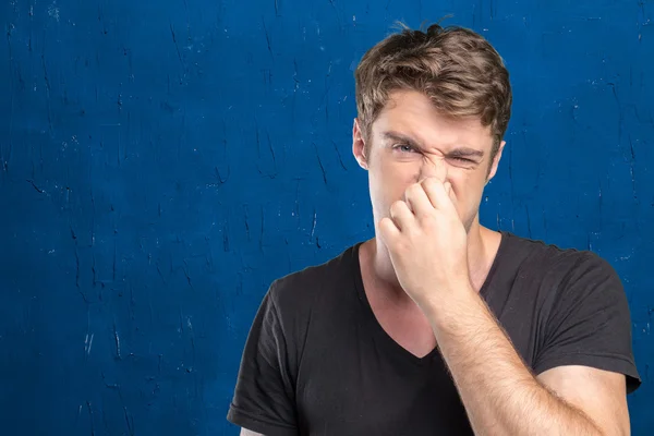 Man håller sin näsa mot en dålig lukt — Stockfoto