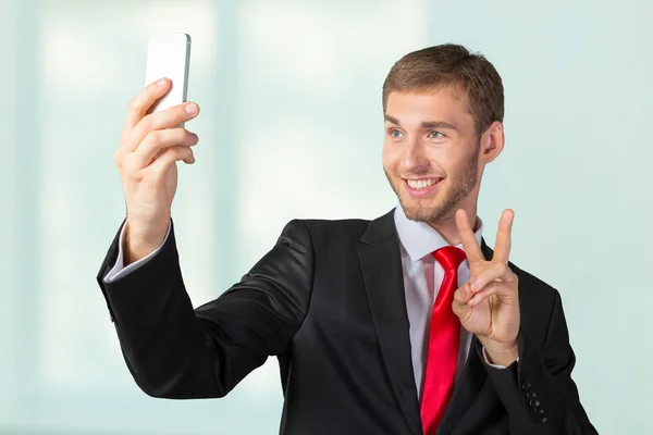 Bir cep telefonu ile bir selfie alarak iş adamı — Stok fotoğraf