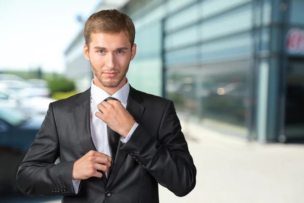 Красивий бізнесмен регулює свою краватку — стокове фото