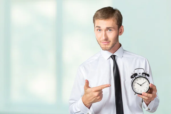 Businessman in formal wear pointing at clock — Stock Photo, Image