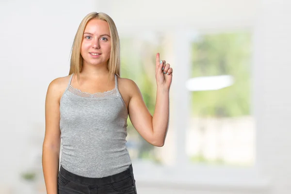 Young woman pointing finger up — Stock Photo, Image