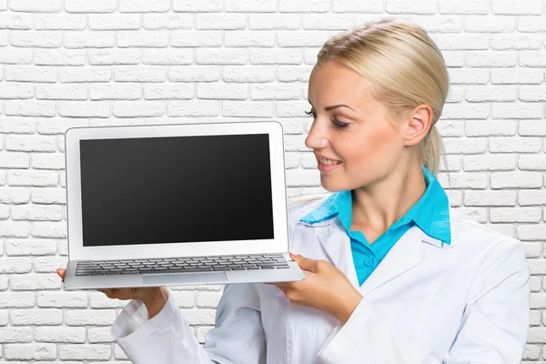 Mulher médico segurando um computador portátil — Fotografia de Stock