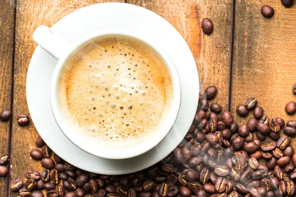 Tasse à café et grains de café sur la table — Photo