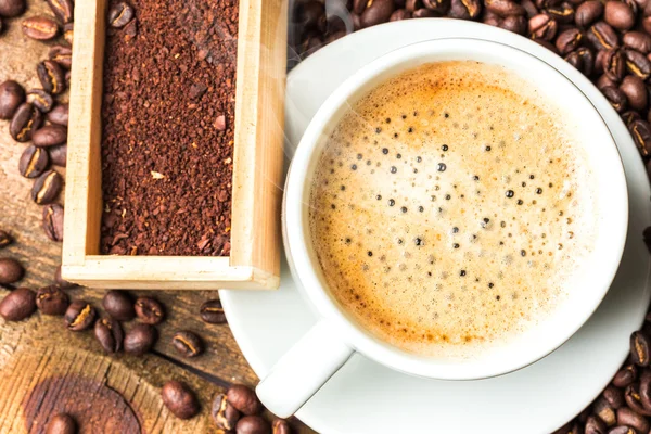 Kahve fincanı ve masada kahve çekirdekleri — Stok fotoğraf