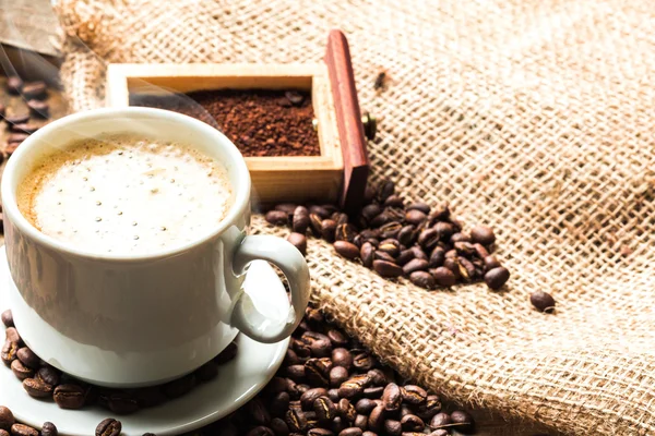 Tasse à café et grains de café sur la table — Photo