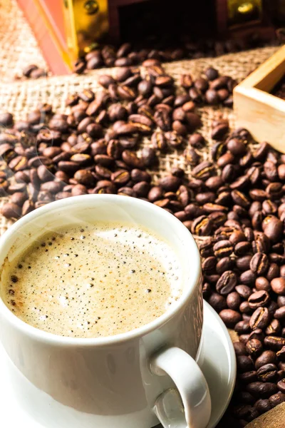 Coffee cup and coffee beans on table — Stock Photo, Image