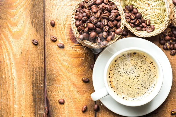 Tasse à café et grains de café sur la table — Photo