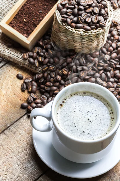 Coffee cup and coffee beans on table — Stock Photo, Image