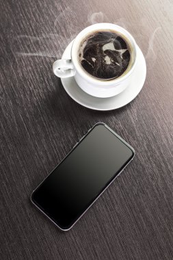 Bir fincan dekore edilmiş kapuçino ve akıllı telefon