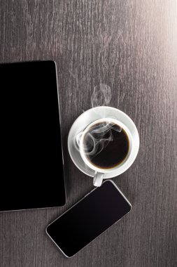 Bir bardak ofcoffee, tablet bilgisayar ve akıllı telefon