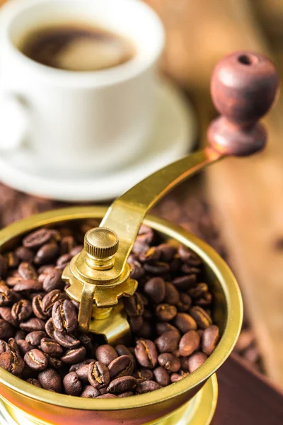 Cup of steaming hot coffee with coffee beans, coffee grinder, and coffee beans bag