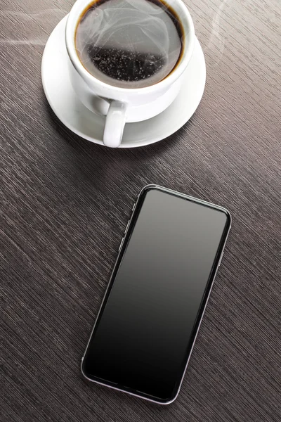 Een kopje ingerichte cappuccino en slimme telefoon — Stockfoto