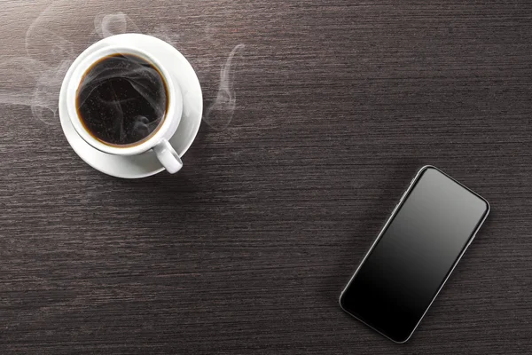 Une tasse de cappuccino décoré et téléphone intelligent — Photo